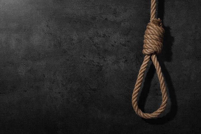 Tied,Rope,Noose,Against,Grey,Stone,Background.,Space,For,Text A noose made of rope hanging against a dark textured background