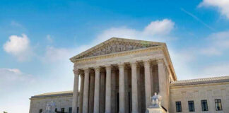 U.S. Supreme Court building exterior under blue sky.