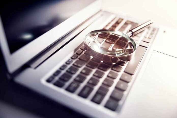 Magnifying,Glass,On,Laptop,Keyboard,Searc,For,Online,Documents,Background A magnifying glass resting on a laptop keyboard