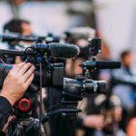Baby Lost, Arrest Follows Fast Video cameras on tripods at a media event