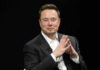 Musk Cheers Far-Right Surge WHERE? Elon Musk in a suit talking.