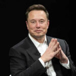 Musk Cheers Far-Right Surge WHERE? Elon Musk in a suit talking.