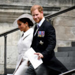 A man and woman walking down outdoor stairs smiling.