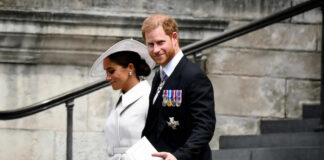 A man and woman walking down outdoor stairs smiling.