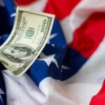 Funflation Hits: Paying More, Playing Less A hundred dollar bill resting on an American flag