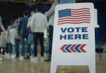 Democrats Abandon Ticket For THIS? People in line next to Vote Here sign