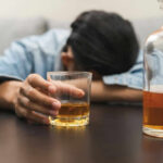 Drinking Plunge Stuns America Person asleep at table holding drink glass