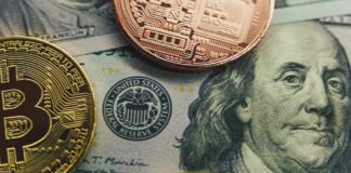 Close-up of a Bitcoin and other coins on a US dollar bill