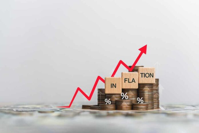 Wooden,Block,And,The,Word,Inflation,On,A,Coin,Placed. Graph showing inflation trend with coins and wooden blocks