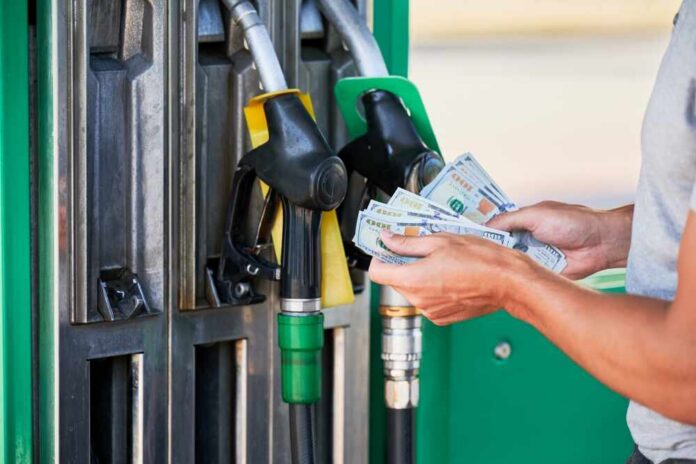 Cropped,View,Of,Man,Shocked,How,Much,Gasoline,Costs.,Driver Person holding cash at a gas station while preparing to refuel