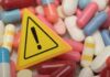 Warning sign among assorted pills and capsules