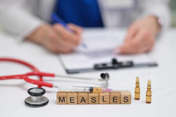 A,Doctor,Carefully,Documents,The,Measles,Vaccination,Process,,Noting,The Measles vaccine concept with stethoscope, syringe, and vials on doctor’s desk