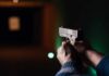 Hands aiming a pistol at an indoor shooting range