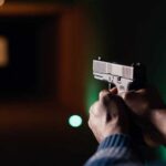 Gunman Breaches Elementary School — Latest Update Hands aiming a pistol at an indoor shooting range