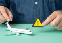 U.S. Issues Travel Alert – City on Edge A person holding a warning sign next to a model airplane