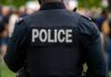 Gunpoint Abduction Sparks Wild Police Chase Back view of a police officer wearing a uniform with 'POLICE' displayed
