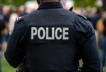 Gunpoint Abduction Sparks Wild Police Chase Back view of a police officer wearing a uniform with 'POLICE' displayed