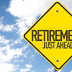 A yellow road sign indicating retirement is just ahead