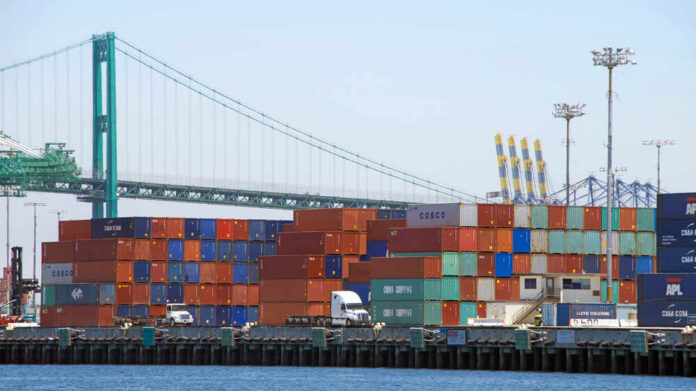 San,Pedro,,Ca,-,July,03,,2017:,Thousands,Of,Shipping A view of stacked shipping containers at a port with a bridge in the background