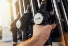 Diesel Blasts Past $6.50 – Drivers Outraged A hand holding a diesel fuel nozzle at a gas station