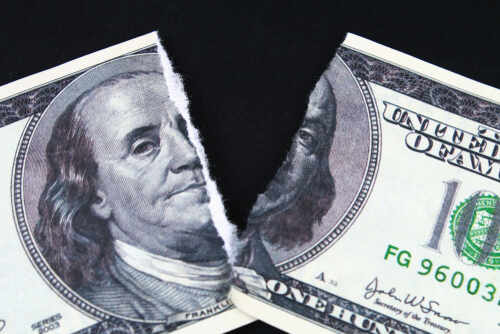 A torn hundred dollar bill featuring Benjamin Franklin