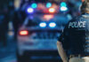 Tip Stops Capitol Terror Nightmare Police officer stands near patrol car with lights flashing.