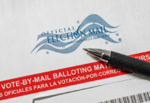 Thumb Drive Standoff Freezes Ballots Vote-by-mail envelope with pen on top.