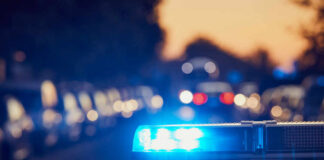 police car light bar flashing on a city street at dusk