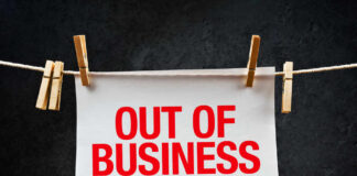 paper sign with red lettering clipped to a clothesline