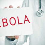 Ebola Outbreak – Airport Misses It Doctor holding a sign about Ebola