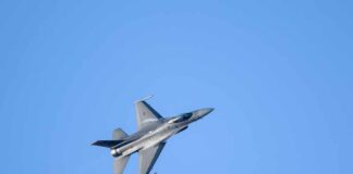 A commercial airplane flying above two military jets in a clear blue sky