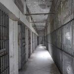 Hostage Playbook Exposed in New Case Empty prison corridor with barred cells on either side