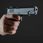 Five Shots. Two Seconds. Now What? Hand holding a semi-automatic pistol pointed forward