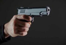 Five Shots. Two Seconds. Now What? Hand holding a semi-automatic pistol pointed forward