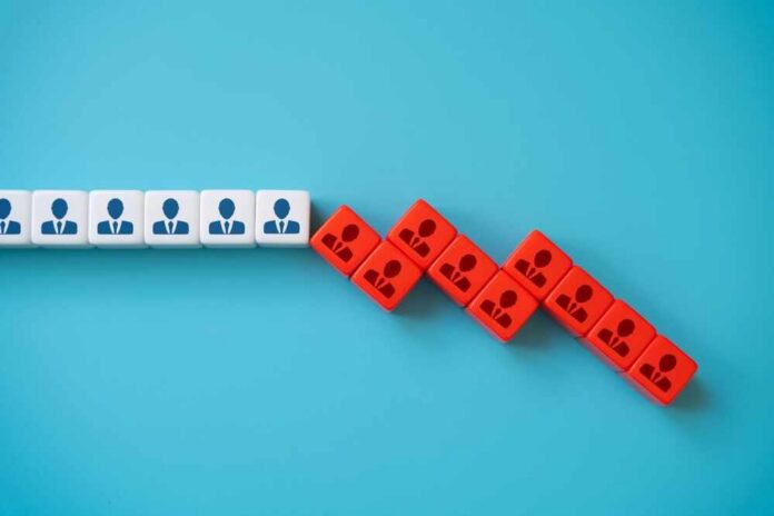 White and red blocks with person icons arranged in a falling domino pattern