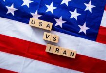 Iran Plot Hits US Base Wood letter blocks on an American flag