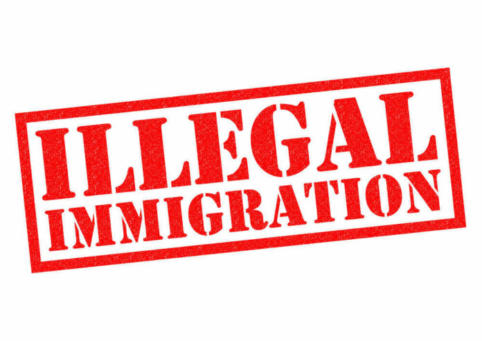 shutterstock_368718257 Red illegal immigration stamp on white background